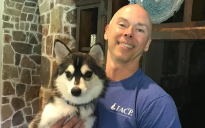 Man holding a puppy, showcasing positive reinforcement dog training in a home setting, emphasizing personalized in-home training for Dallas dog owners.